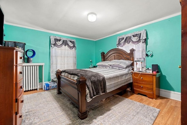 bedroom featuring wood finished floors, ornamental molding, radiator heating unit, and baseboards