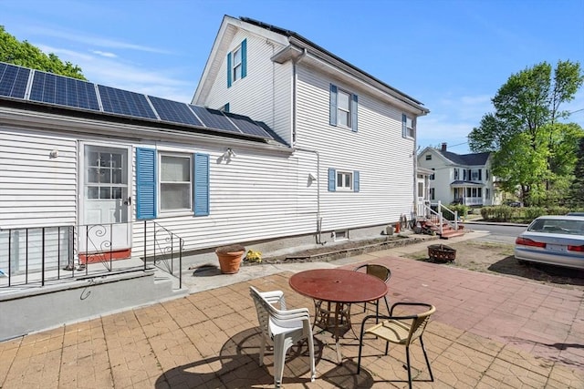 rear view of property featuring solar panels and entry steps