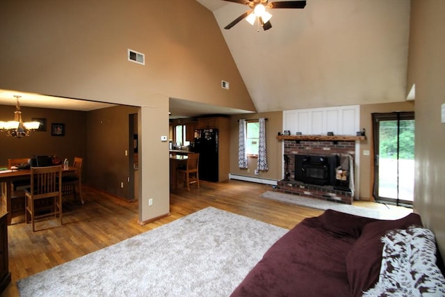 31 Trudeau Ln, East Bridgewater, MA 02333 - living area featuring baseboard heating, high vaulted ceiling, light wood-type flooring, a chandelier, and healthy amount of natural light