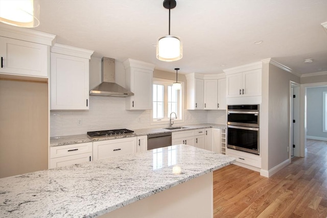 kitchen featuring decorative light fixtures, white cabinetry, wall chimney range hood, and stainless steel appliances