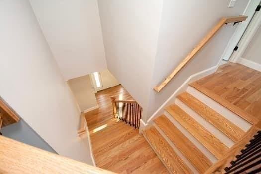 staircase featuring radiator heating unit and wood-type flooring