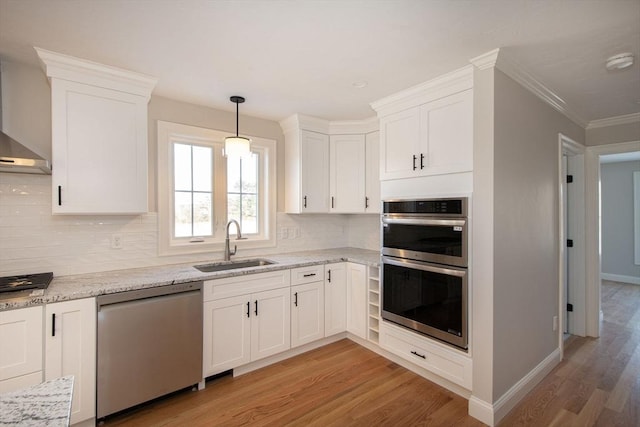 kitchen with light stone countertops, sink, light hardwood / wood-style flooring, white cabinets, and appliances with stainless steel finishes