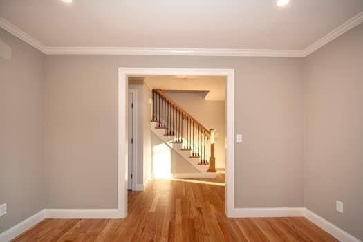 spare room featuring wood-type flooring and ornamental molding