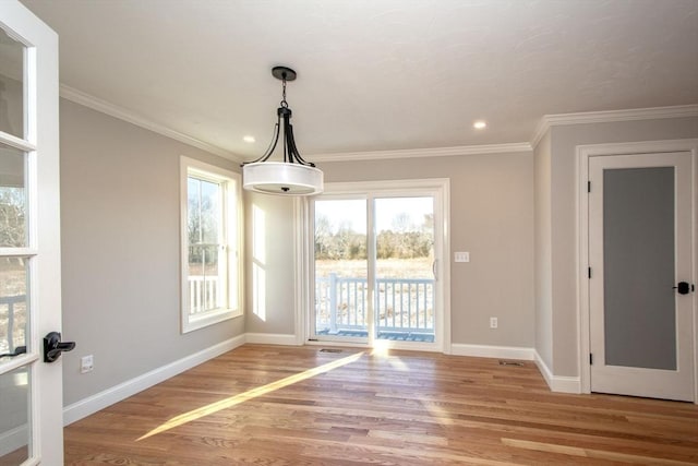 unfurnished dining area with light wood-type flooring and crown molding