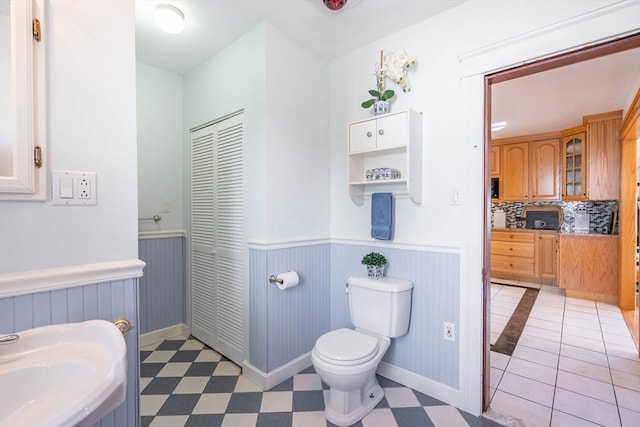 204 Massasoit Rd, Worcester, MA 01604 - bathroom with a wainscoted wall, toilet, tile patterned floors, tasteful backsplash, and baseboards