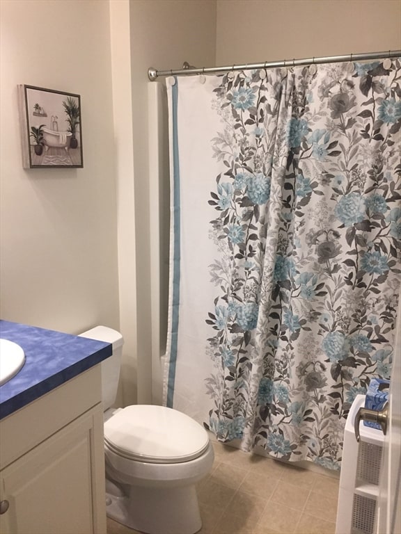 bathroom featuring vanity, toilet, a shower with curtain, and tile patterned floors