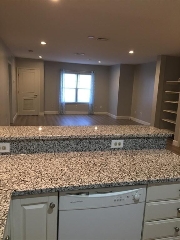 kitchen featuring white dishwasher, recessed lighting, wood finished floors, white cabinetry, and light stone countertops