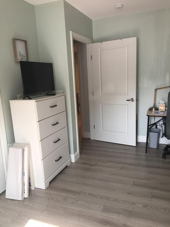 bedroom featuring light wood finished floors and baseboards