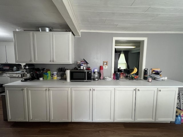 104 Temple St, Gardner, MA 01440 - kitchen featuring stainless steel microwave, light countertops, dark wood-type flooring, ornamental molding, and white cabinets