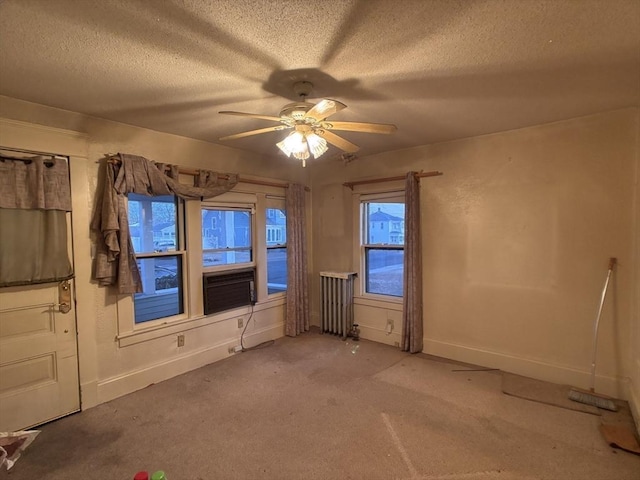 empty room with ceiling fan, carpet, a textured ceiling, and radiator