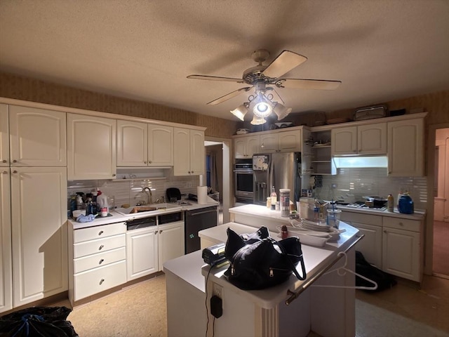 kitchen with a kitchen island, stainless steel appliances, white cabinetry, and sink