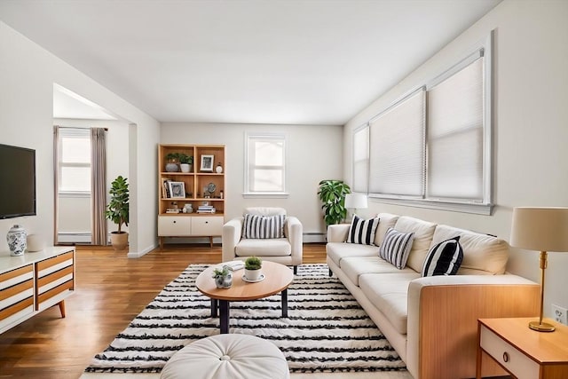 living room featuring dark wood-type flooring and baseboard heating