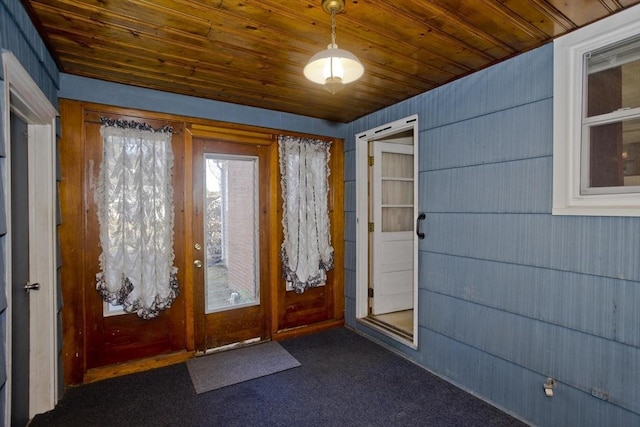 entryway with wood ceiling and dark colored carpet