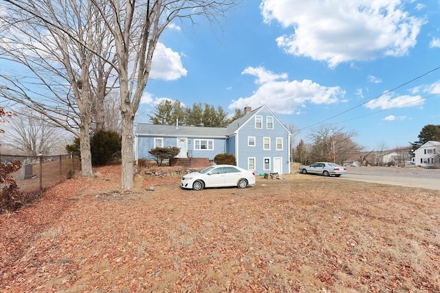 view of front of property featuring a chimney and fence