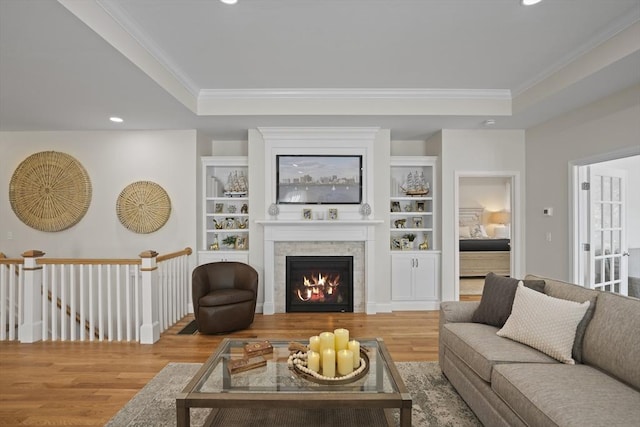 living room with hardwood / wood-style flooring, ornamental molding, and a tray ceiling