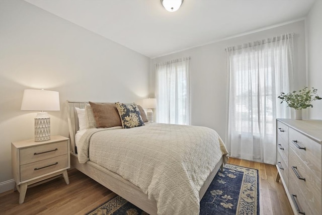 bedroom with multiple windows and light wood-type flooring