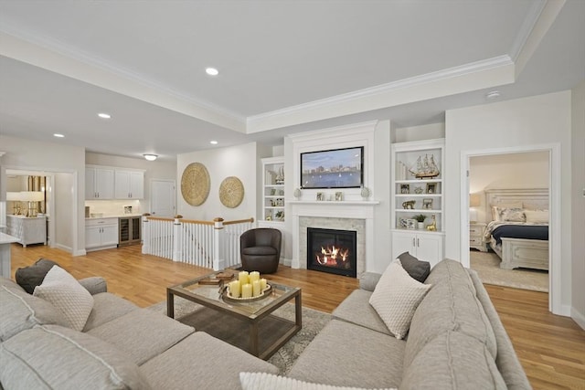 living room with wine cooler, crown molding, and light hardwood / wood-style floors