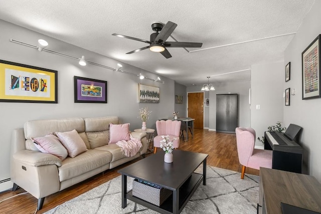 10 Williams St Unit 45, Watertown, MA 02472 - living area with a textured ceiling, ceiling fan with notable chandelier, wood finished floors, and a baseboard heating unit