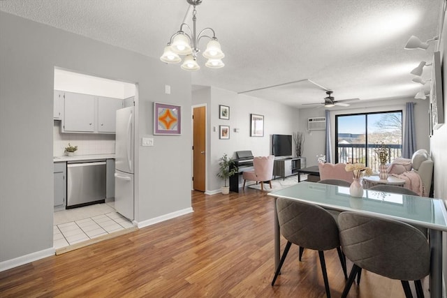 10 Williams St Unit 45, Watertown, MA 02472 - dining space with a textured ceiling, ceiling fan with notable chandelier, light wood-type flooring, and a wall mounted air conditioner