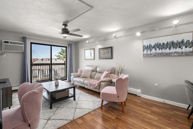 10 Williams St Unit 45, Watertown, MA 02472 - living area featuring a baseboard radiator, a wall mounted AC, wood finished floors, and a ceiling fan