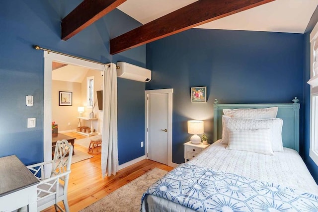 bedroom featuring a wall mounted air conditioner, light hardwood / wood-style flooring, and lofted ceiling with beams