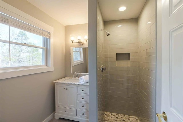 bathroom with vanity and tiled shower