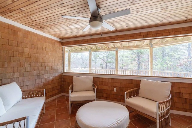 sitting room with ceiling fan, tile patterned floors, and wood ceiling