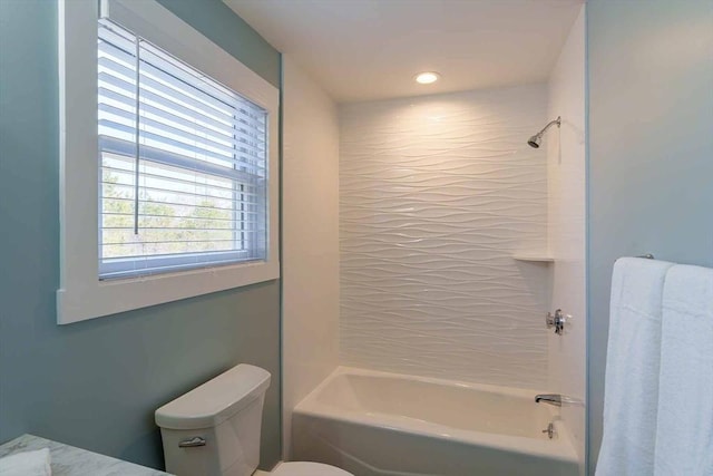 bathroom featuring tiled shower / bath and toilet