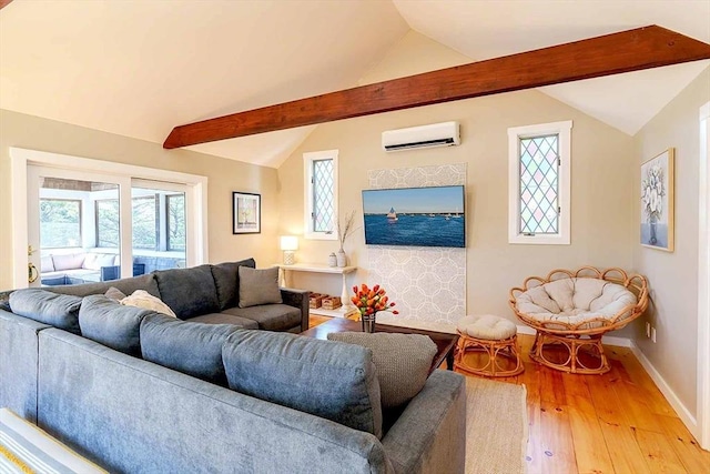 living room with hardwood / wood-style flooring, a wealth of natural light, lofted ceiling with beams, and an AC wall unit