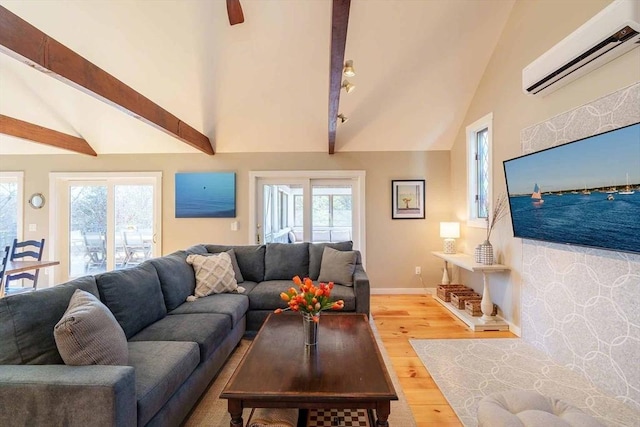 living room with wood-type flooring, a wealth of natural light, a wall unit AC, and vaulted ceiling with beams