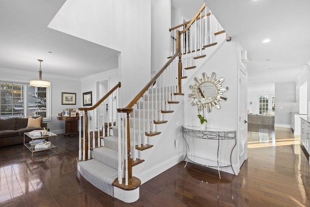 staircase with hardwood / wood-style flooring and ornamental molding