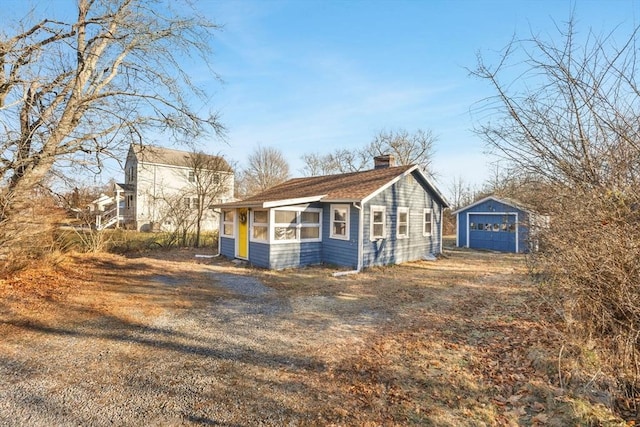 view of property exterior with a garage and an outdoor structure