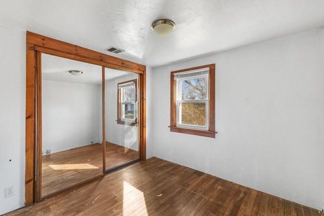 unfurnished bedroom with a closet and hardwood / wood-style floors