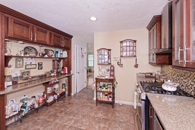 11 Azalea Ln Unit 11, Marlborough, MA 01752 - kitchen featuring stainless steel gas stove, decorative backsplash, wall chimney exhaust hood, open shelves, and light stone counters