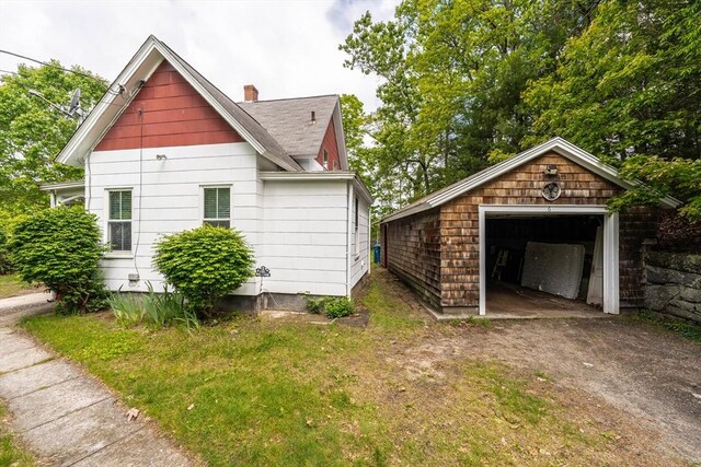 6 Oak St, Monson, MA 01057 - view of side of property featuring an outbuilding, a detached garage, a chimney, dirt driveway, and a shingled roof