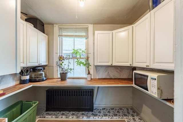 6 Oak St, Monson, MA 01057 - kitchen with radiator heating unit, butcher block counters, white microwave, and white cabinets