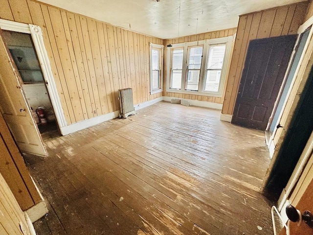 205 Saint James Ave, Springfield, MA 01109 - empty room with radiator heating unit, wood-type flooring, and wooden walls
