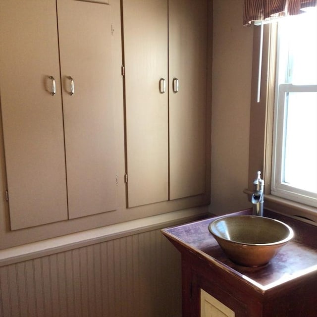 bathroom featuring vanity and wooden walls