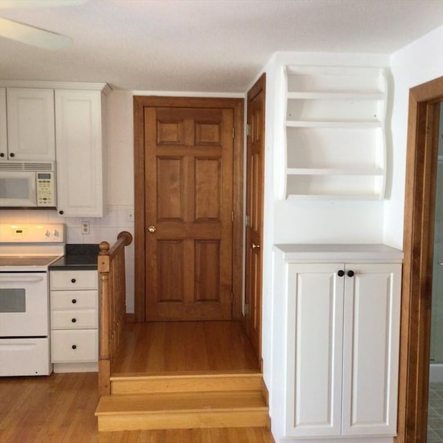 kitchen featuring white cabinetry, white appliances, decorative backsplash, and light wood-type flooring