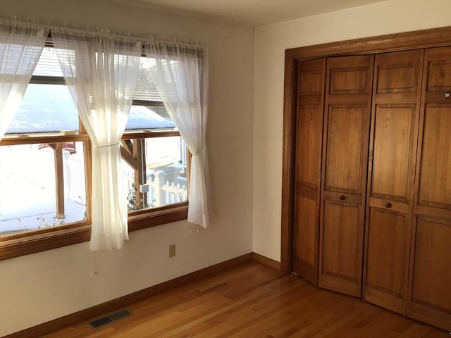 unfurnished bedroom with light hardwood / wood-style floors and a closet