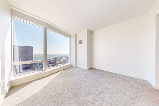 carpeted spare room featuring a water view