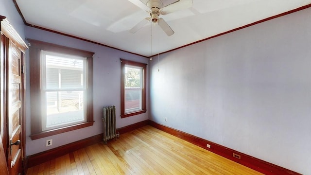 15-17 Brockton Ave, Haverhill, MA 01830 - spare room with radiator heating unit, light wood-style flooring, ornamental molding, baseboards, and a ceiling fan