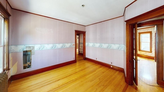 15-17 Brockton Ave, Haverhill, MA 01830 - spare room featuring crown molding, wood finished floors, radiator, wallpapered walls, and a pendent fire sprinkler