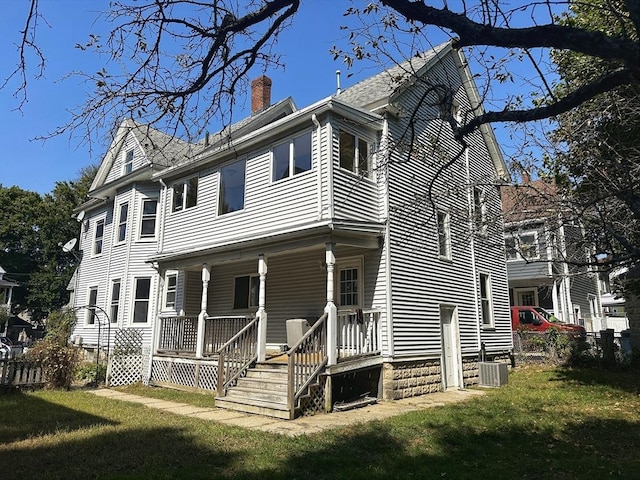 15-17 Brockton Ave, Haverhill, MA 01830 - view of side of property featuring a chimney, a porch, cooling unit, and a lawn