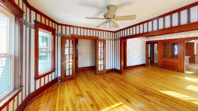 15-17 Brockton Ave, Haverhill, MA 01830 - spare room with ornamental molding, french doors, hardwood / wood-style flooring, wallpapered walls, and a ceiling fan
