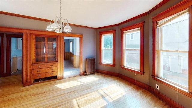 15-17 Brockton Ave, Haverhill, MA 01830 - empty room with radiator heating unit, a chandelier, light wood-type flooring, baseboards, and crown molding