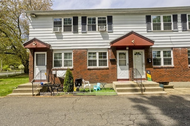 view of property featuring brick siding and cooling unit