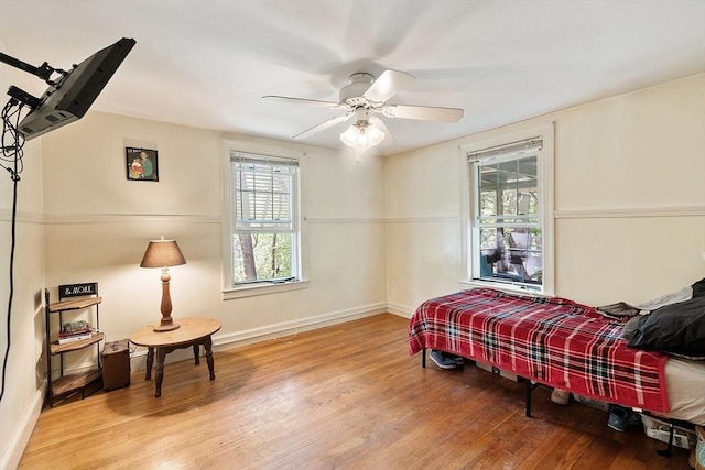 bedroom featuring wood finished floors, baseboards, and a ceiling fan