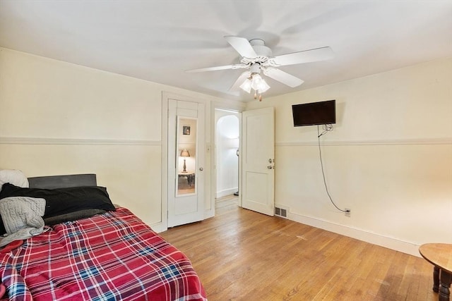 bedroom with wood finished floors, baseboards, and a ceiling fan