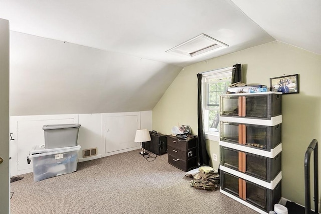 office space featuring attic access, vaulted ceiling, and carpet